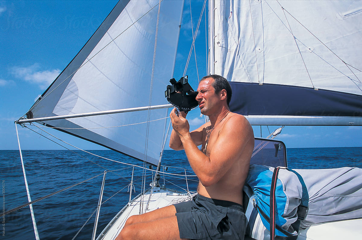 a sailor is using a sextant to determine his location