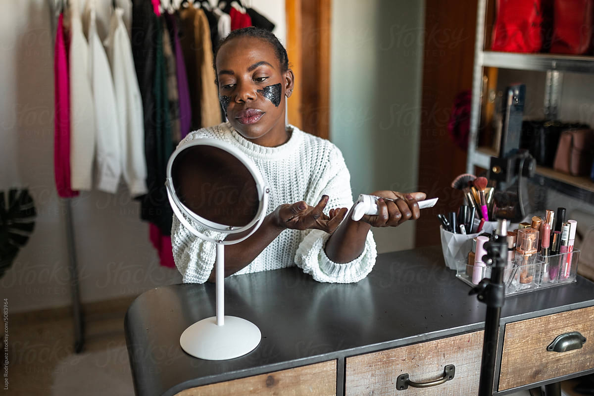 black woman blogger doing makeup at home