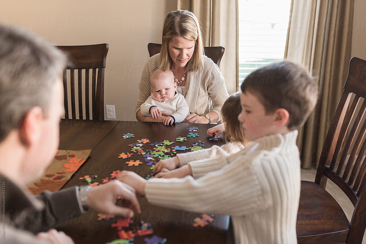 A Large Family Plays With A Puzzle