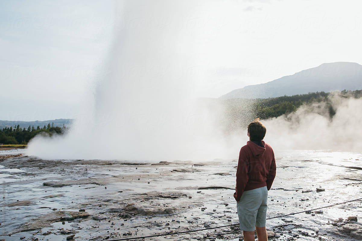 Man looking at geyser in Iceland