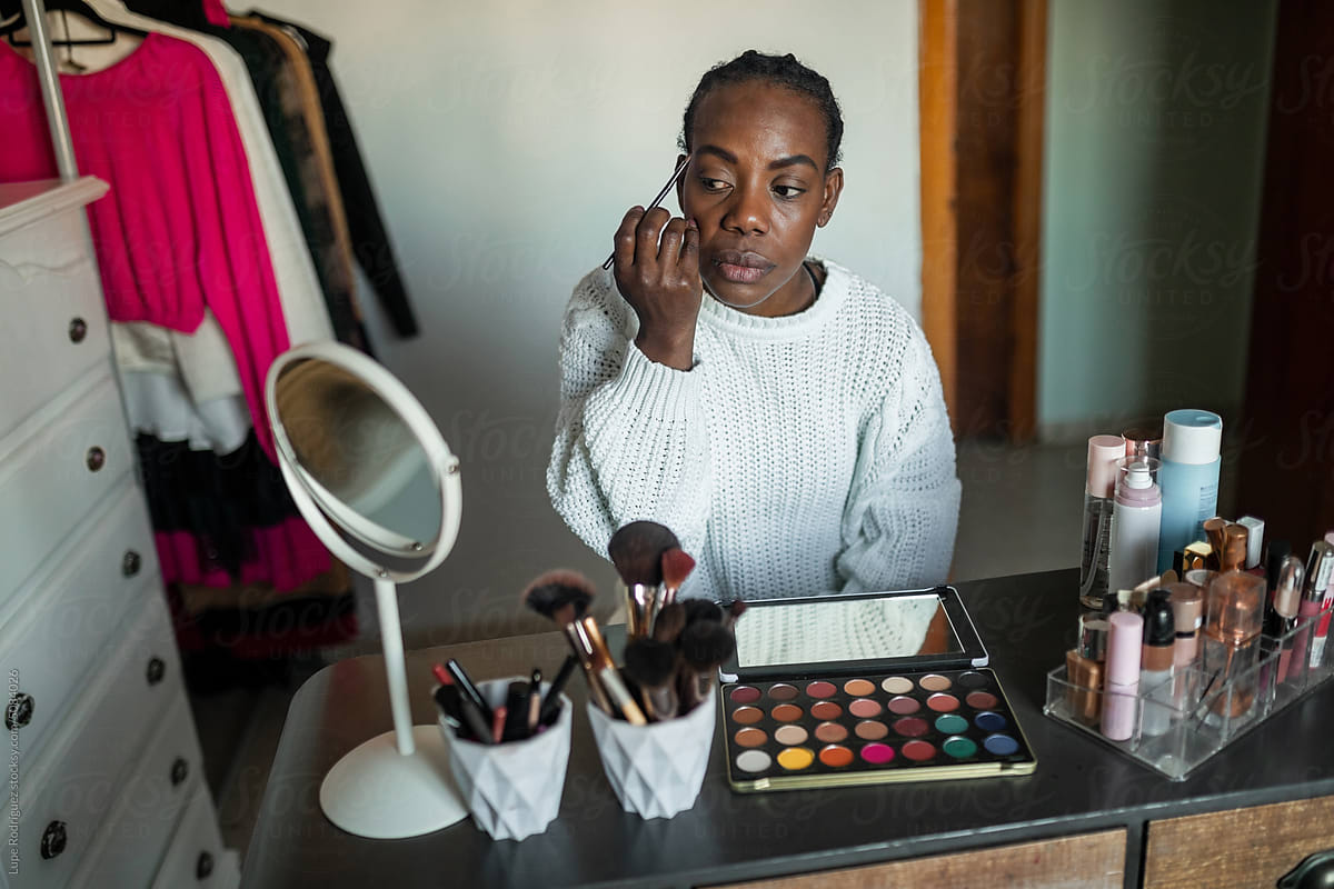black woman doing makeup at home