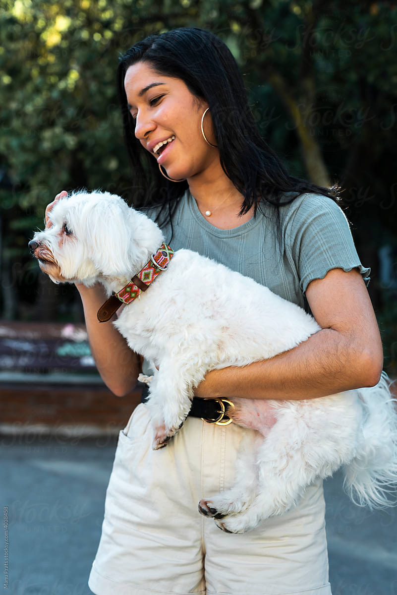 Brown skinned woman holding pet