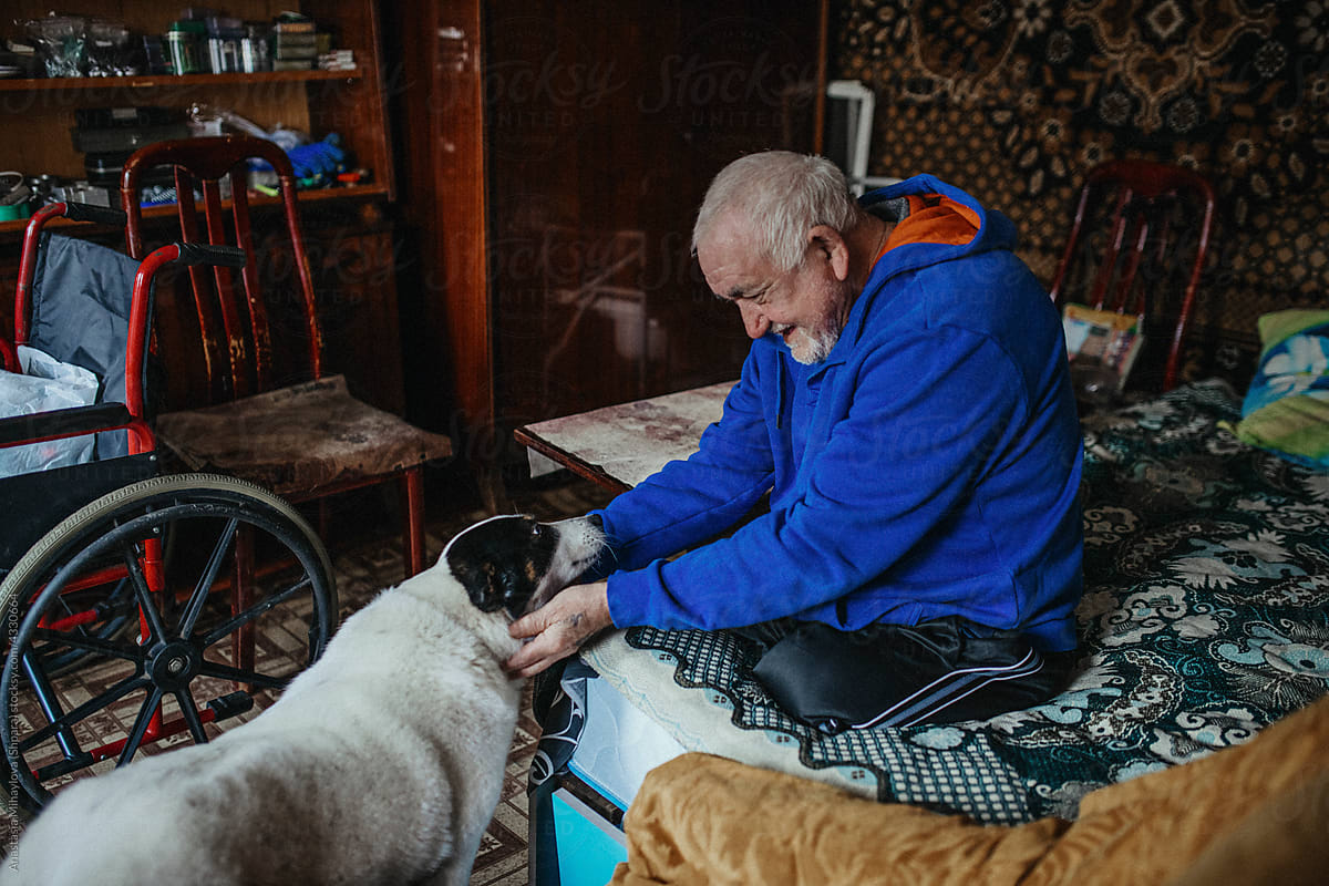 Physically Disabled Man Petting His Dog at home