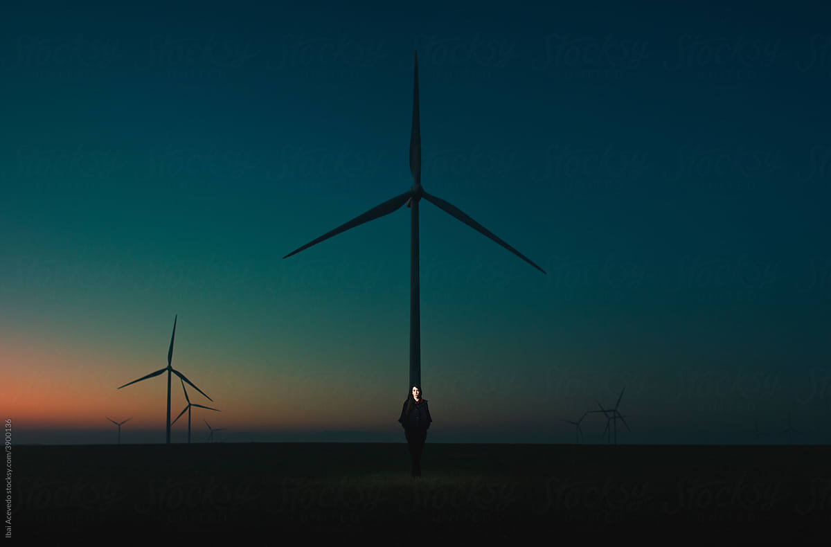 Surreal portrait of standing woman near windmill