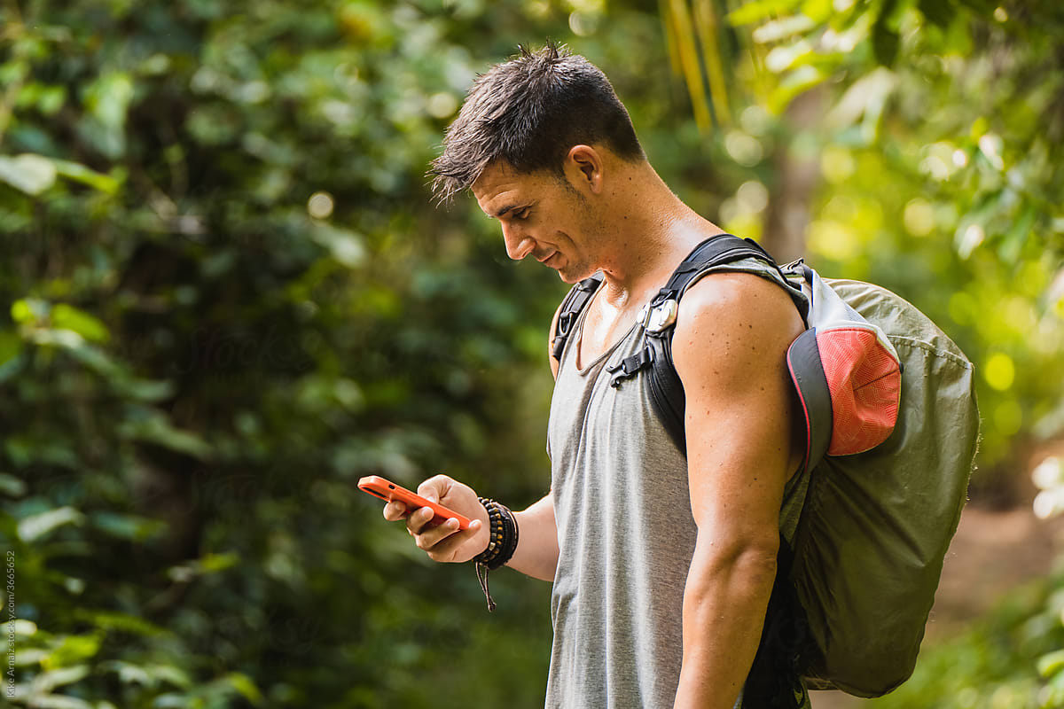 Man Using Phone in Tropical Forest