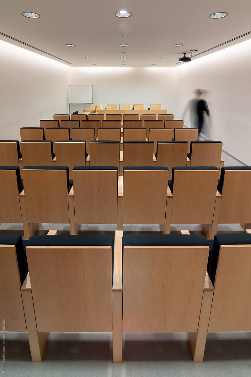 Person walking in meeting room with rows of chairs