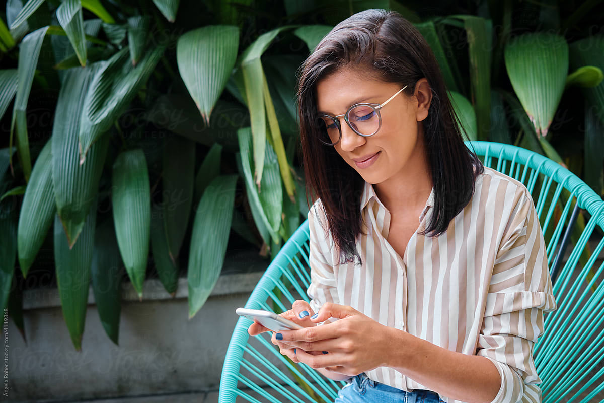 Young woman with glasses sending a text message