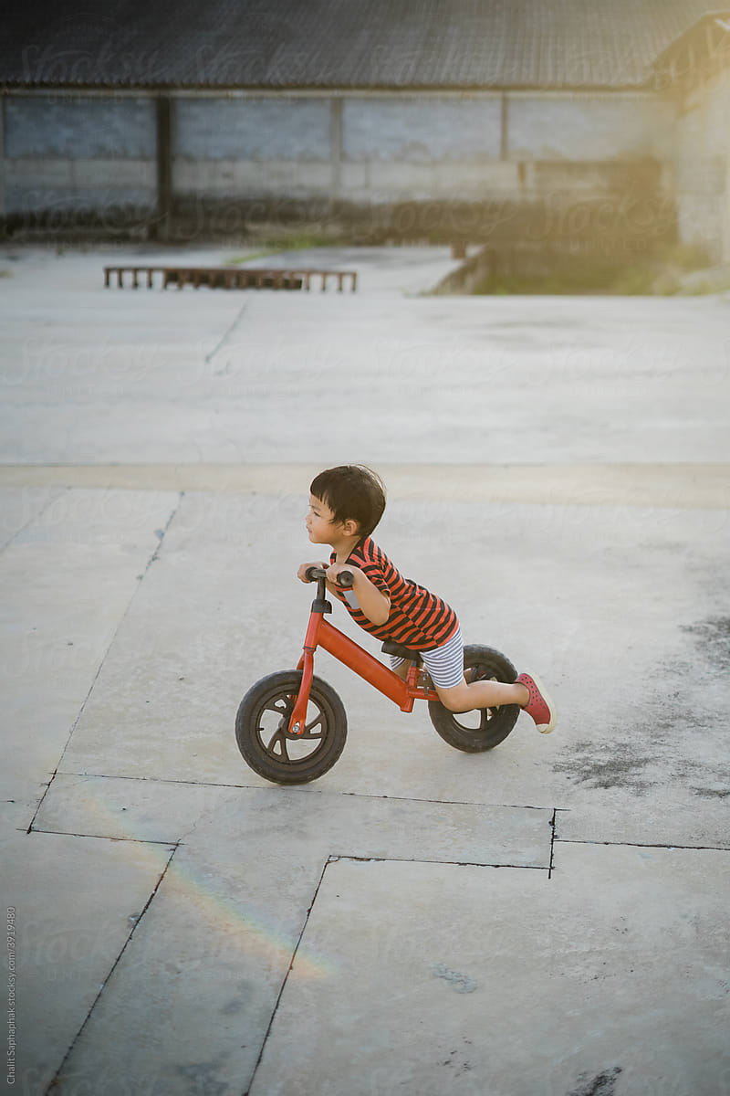 Asian kids riding a balance bike.