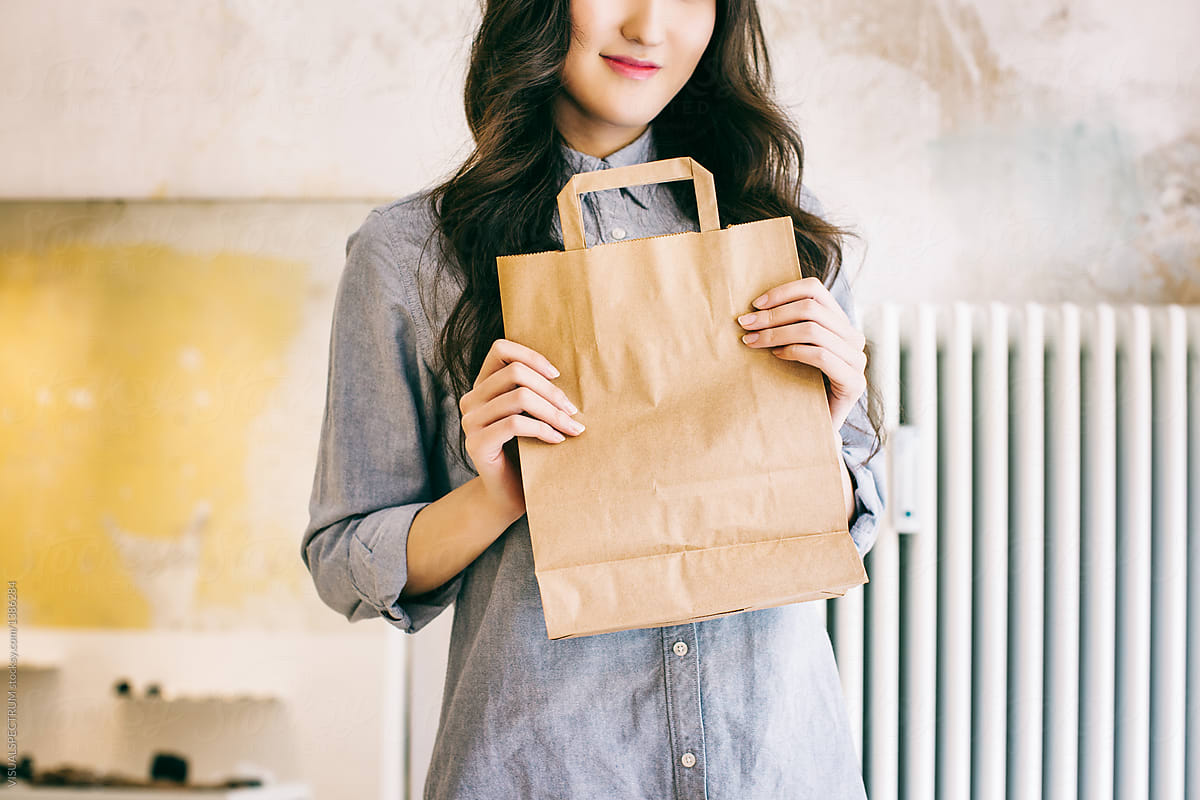 Closeup of Young Asian Woman Holding Paper Shopping Bag in Beautiful Store