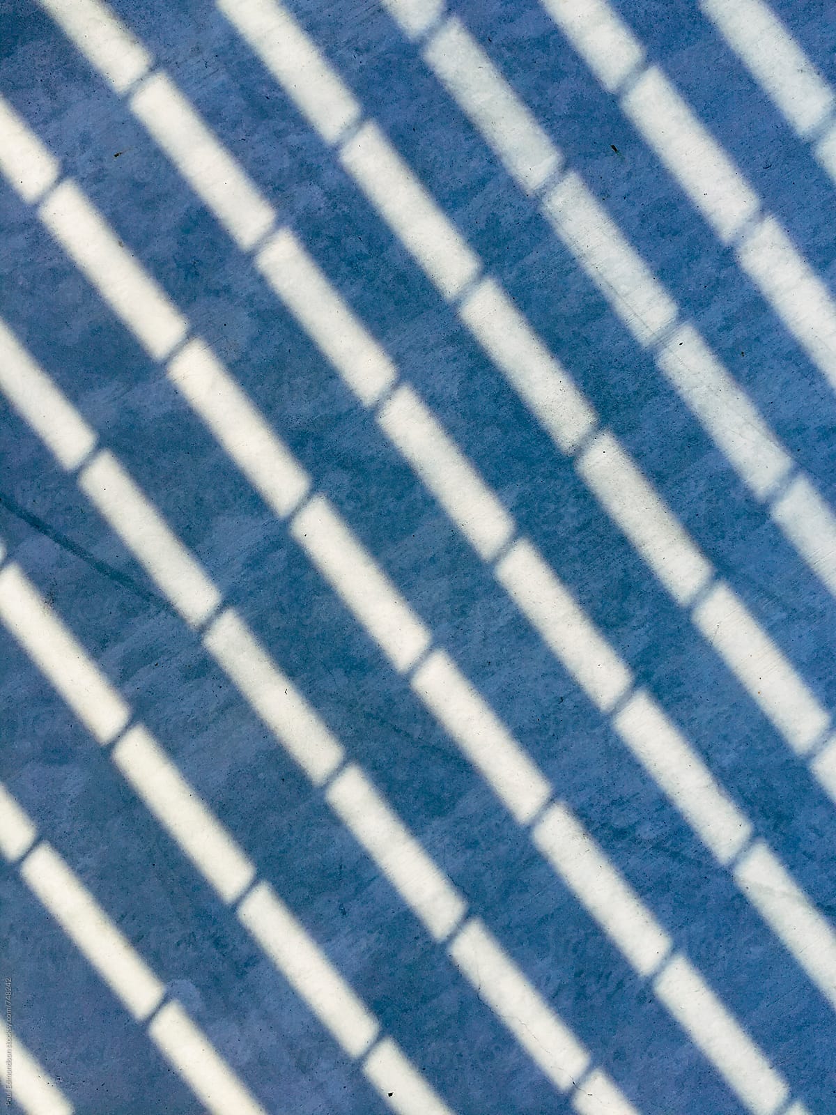 Graphic shadows and lines on concrete sidewalk