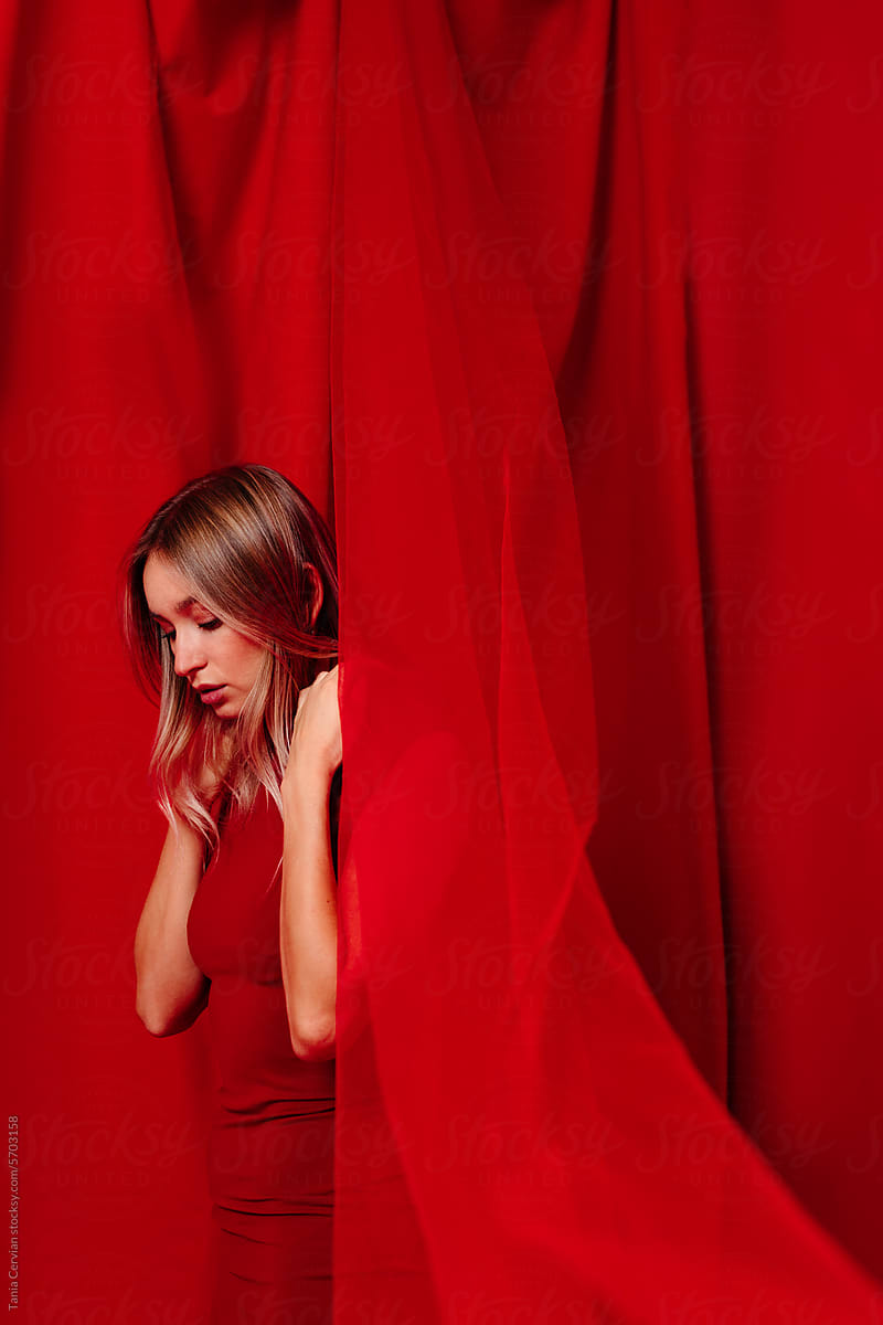 Stylish calm female against red curtain