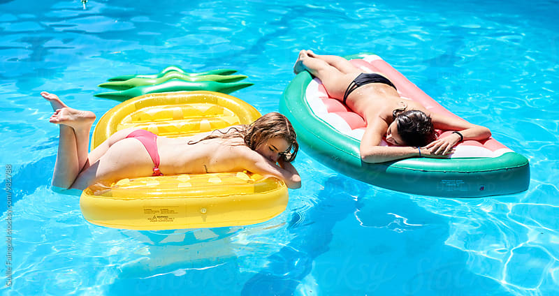 Two topless girls sunbathing on air mattress