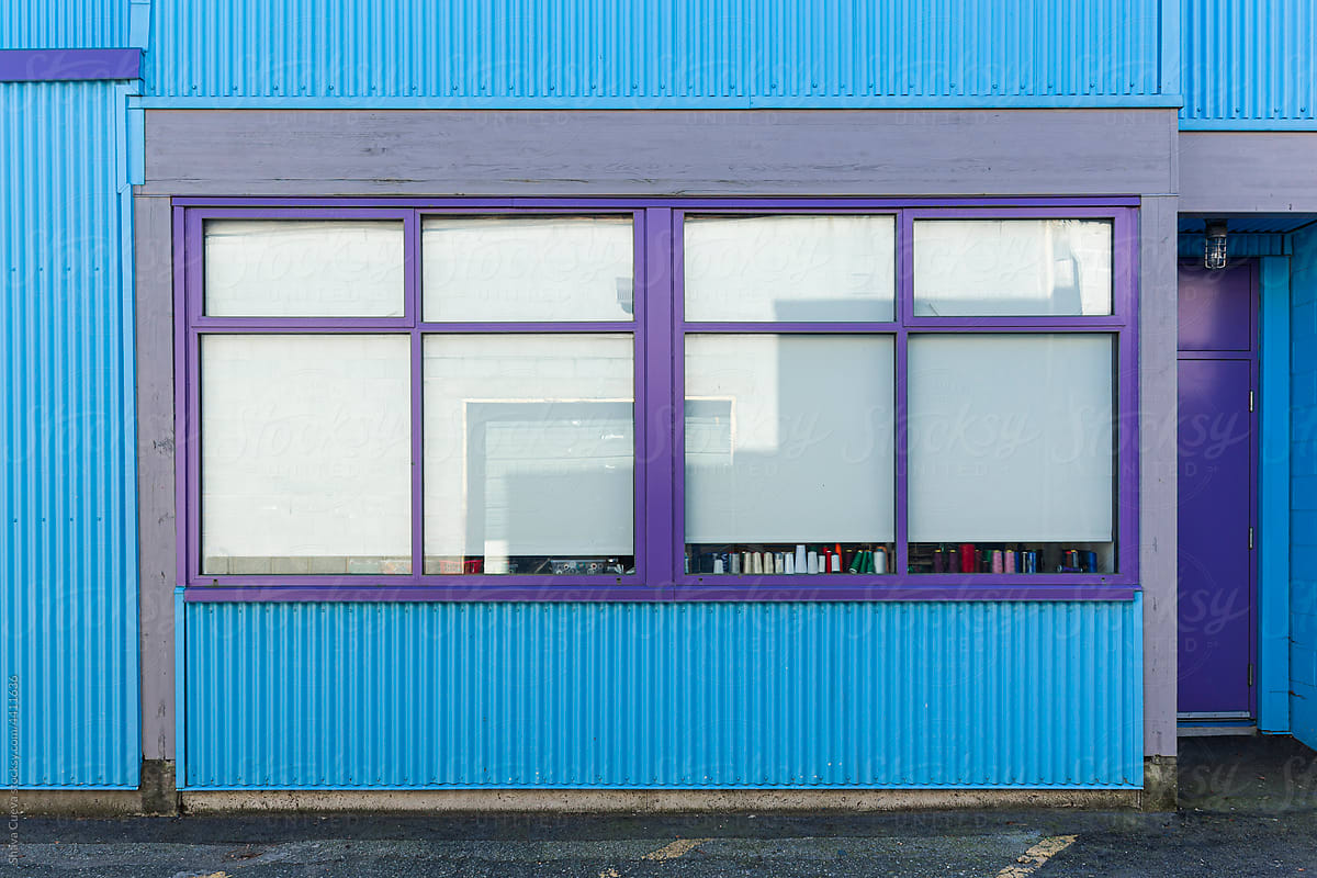 A blue colored aluminum building with  two windows