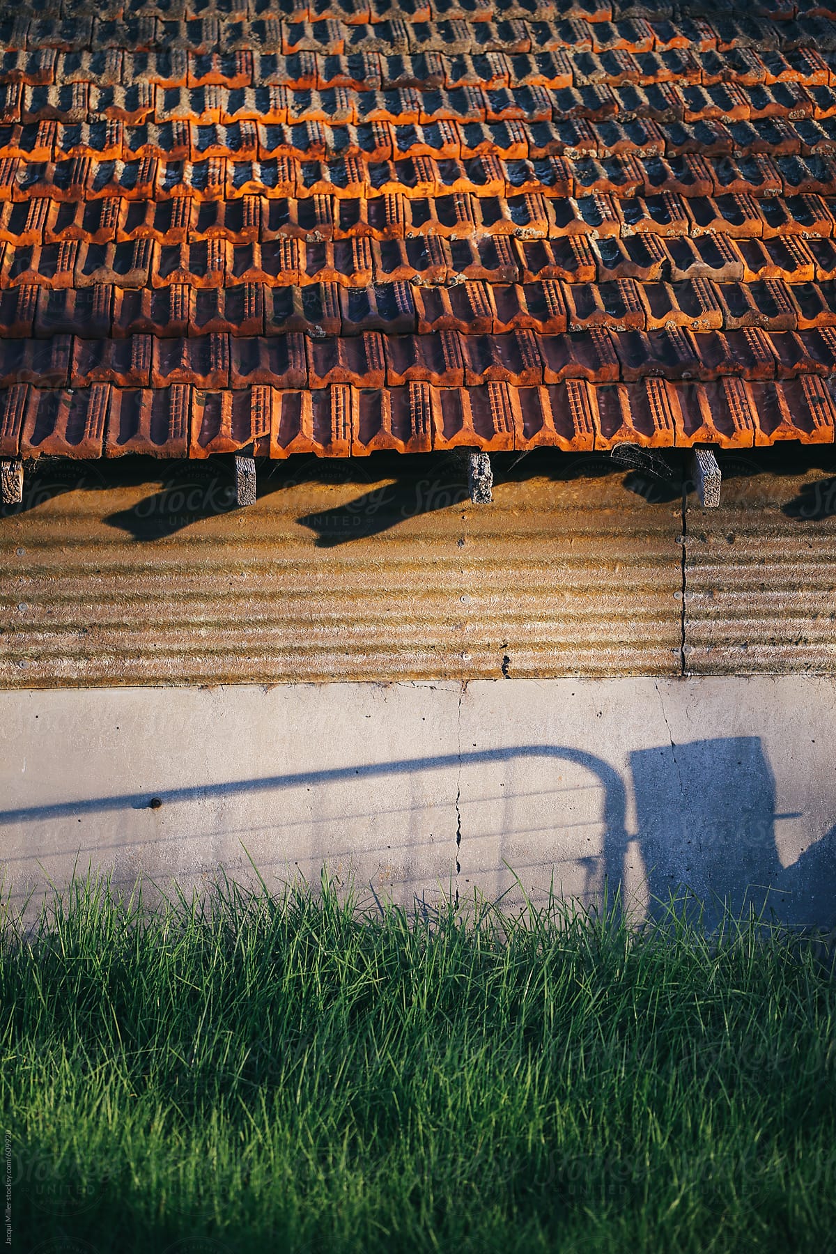Layers of an old farm building with shadow of gate on wall - vertical