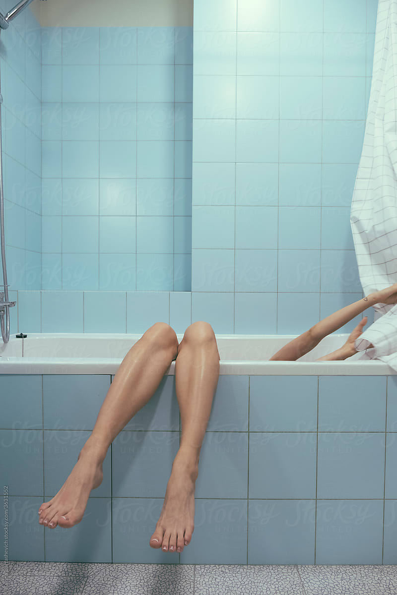 Photo Of A Girl In A Vintage Blue Bathroom Whose Legs Hang From The