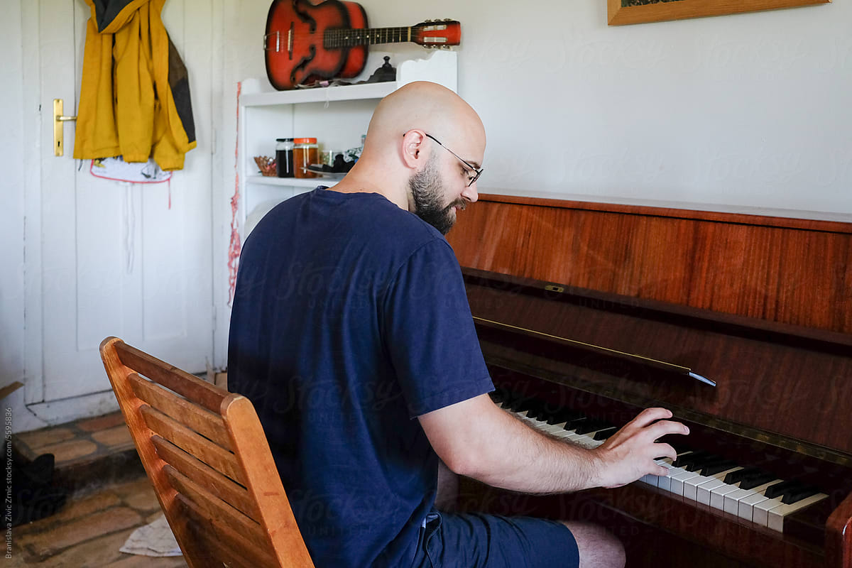 Man Enjoying Playing The Piano At Her Home