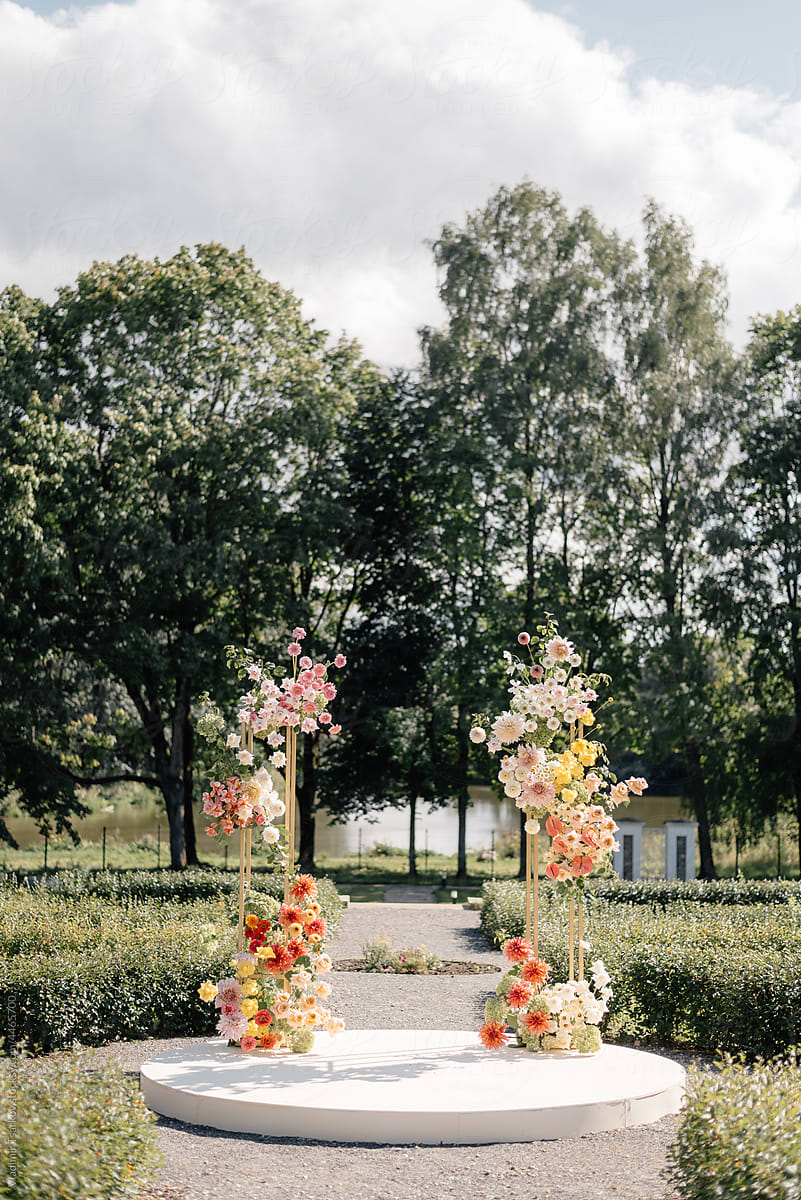 podium with flower installation in wedding arch shape