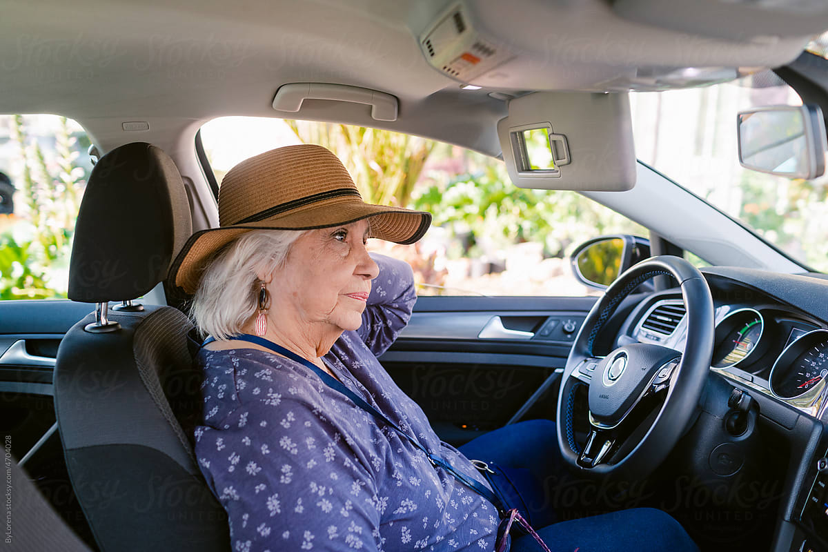 Senior female driver waiting inside car