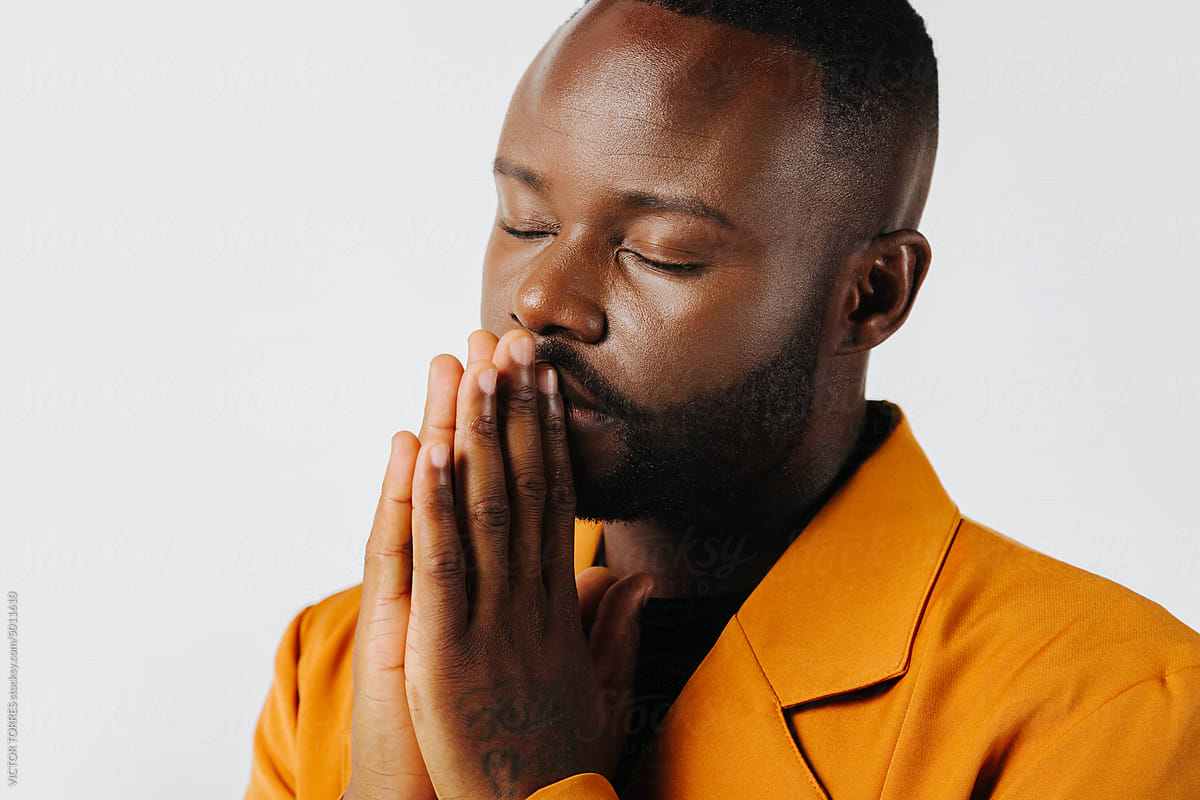Elegant black man with orange suit praying
