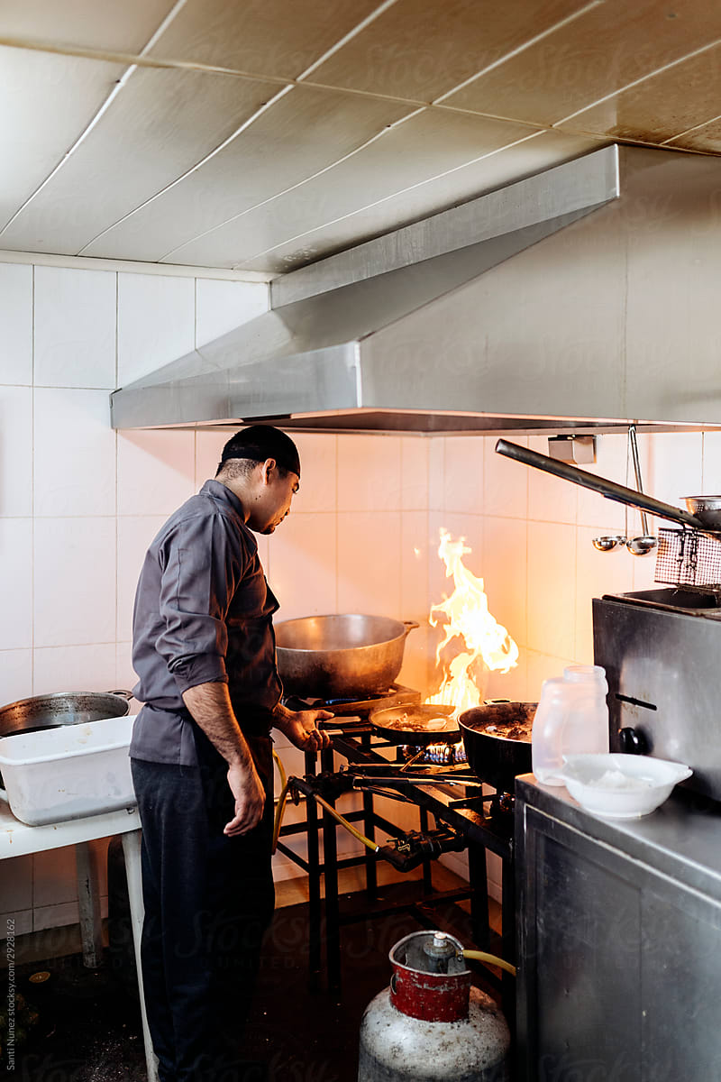 Chef preparing food in kitchen.