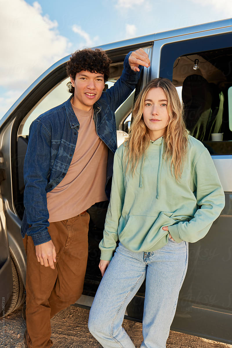 Happy young cuouple standing near caravan