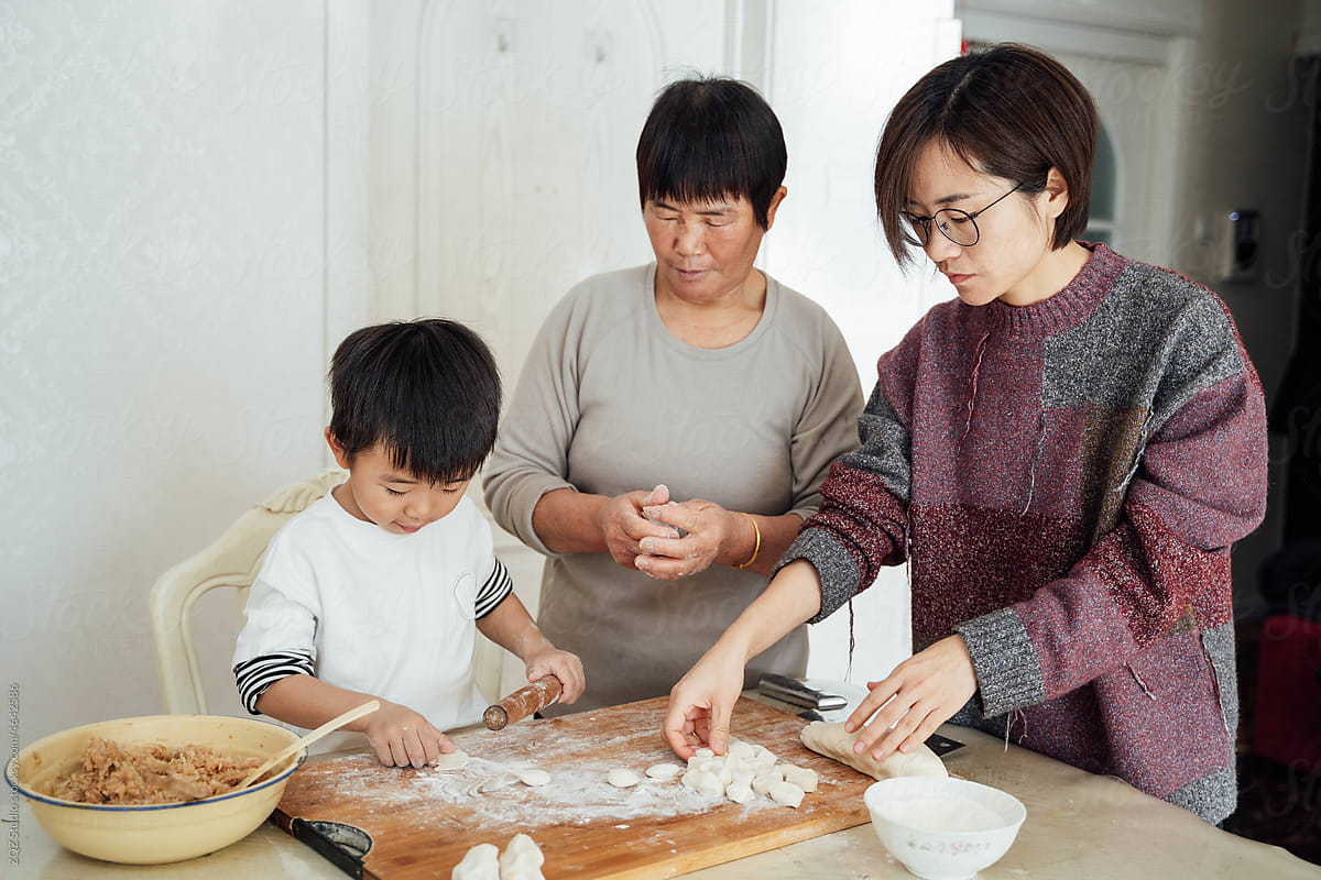Cute boy cooking with grandma and mother