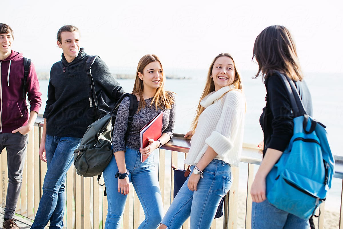 Group of teen students talking after school on the street.
