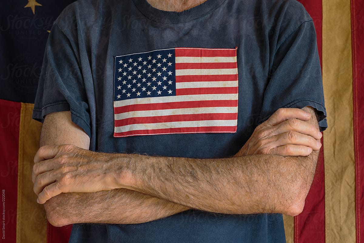 Man in faded, threadbare tee shirt with American flag