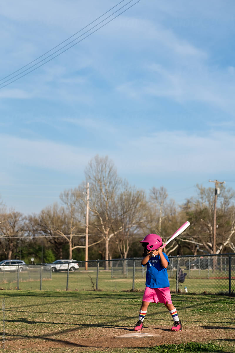 Girl playing baseball wearing colorful uniform 3