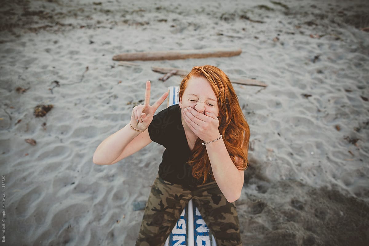 Portrait Of Redhead Teenage Girl Sitting At The Beach Being Goof By 