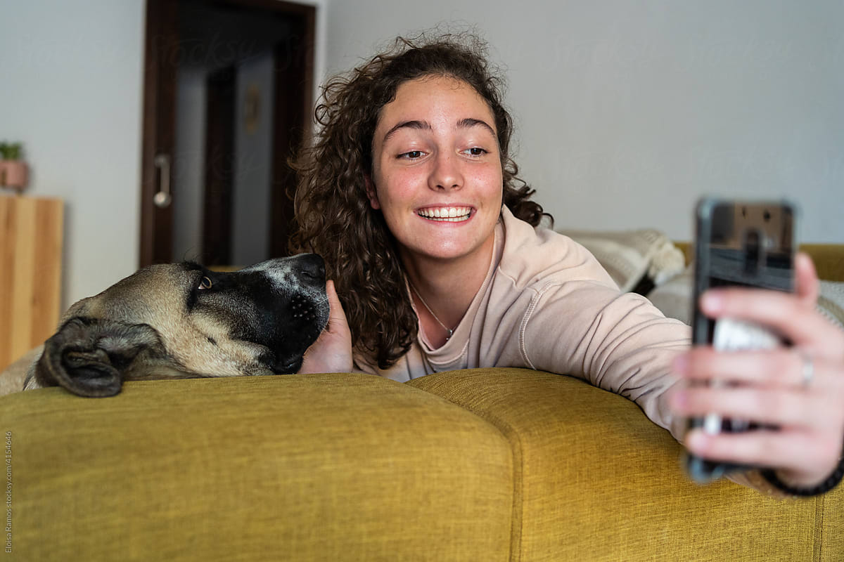 Teen taking selfie with her doggy
