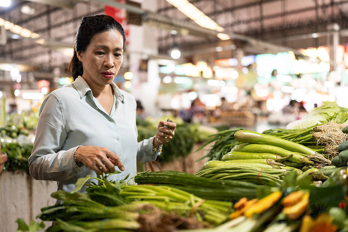 Woman buying vegetables in a market.