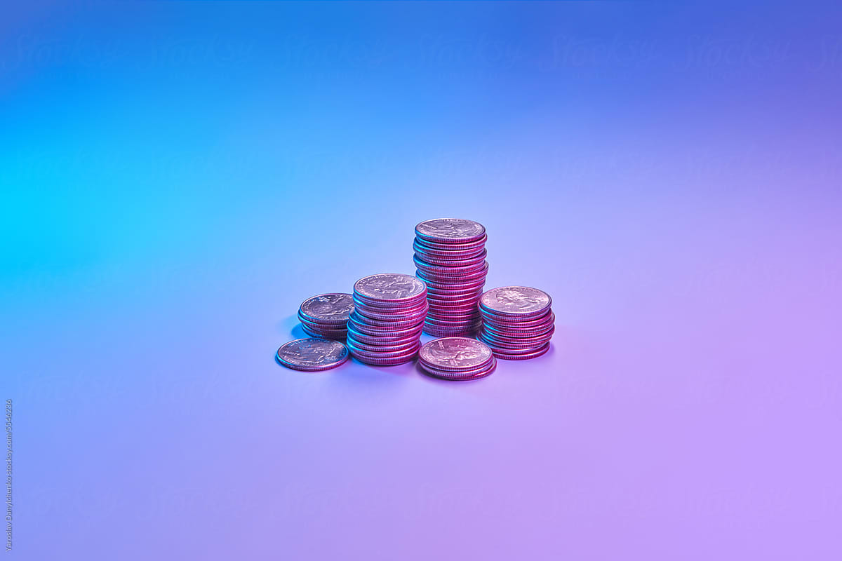Pile of coins against multicolored background.