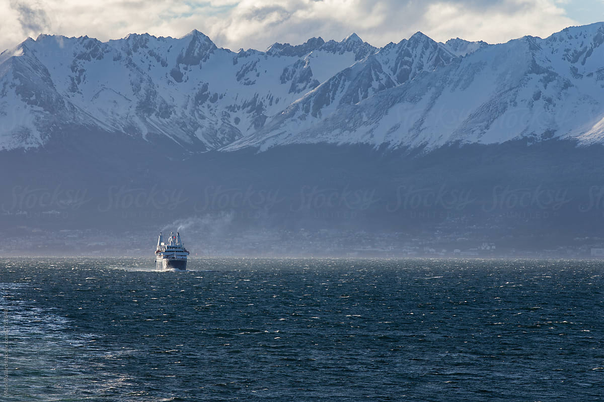 Ferry Surrounded by Dramatic Peaks at Sunset