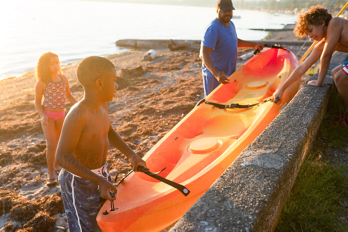 Family lowers kayak down to beach