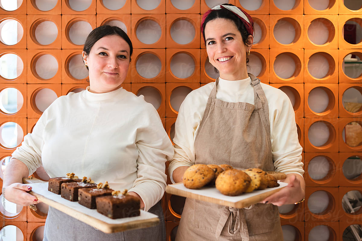 Optimist bakers with freshly baked cake and biscuit