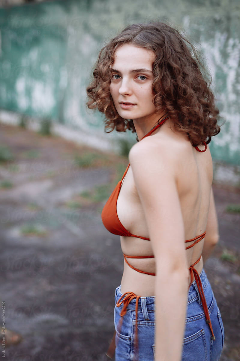 Candid portrait of a curly hair woman in a old urban area