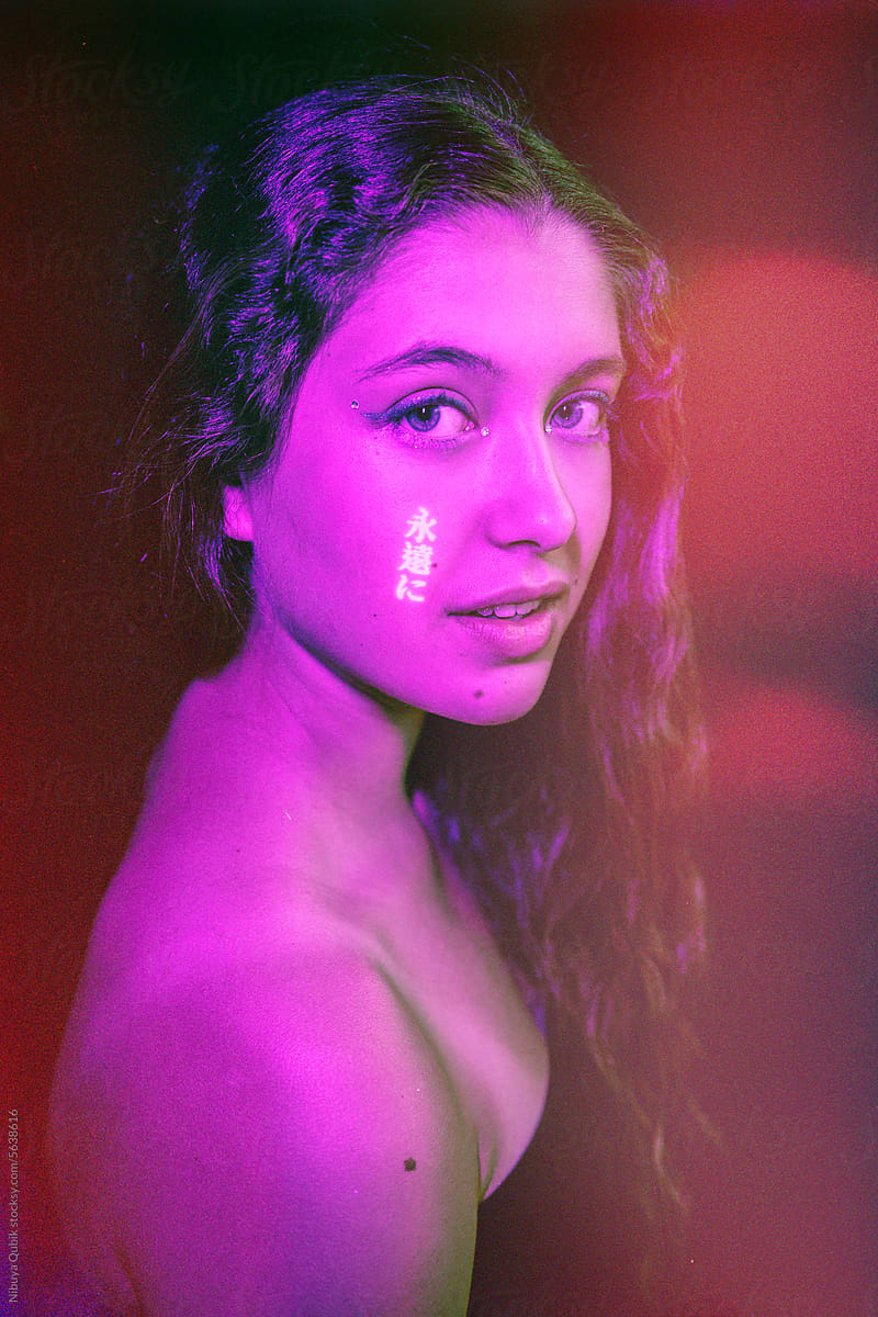 studio portrait with neon lights of attractive woman looking at camera