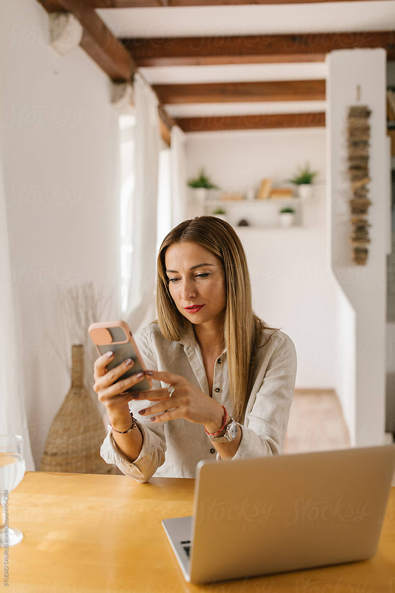 Businesswoman using smartphone at home