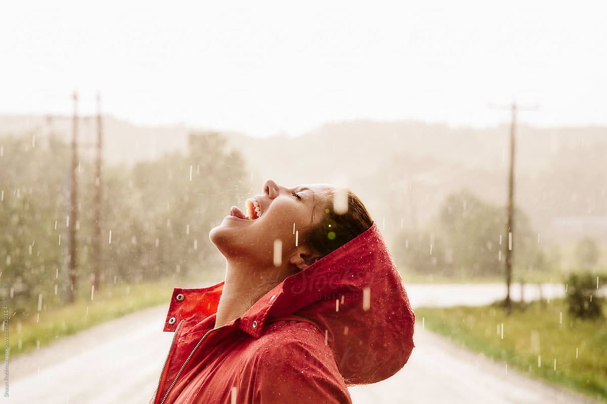 woman catching rain drops in her mouth