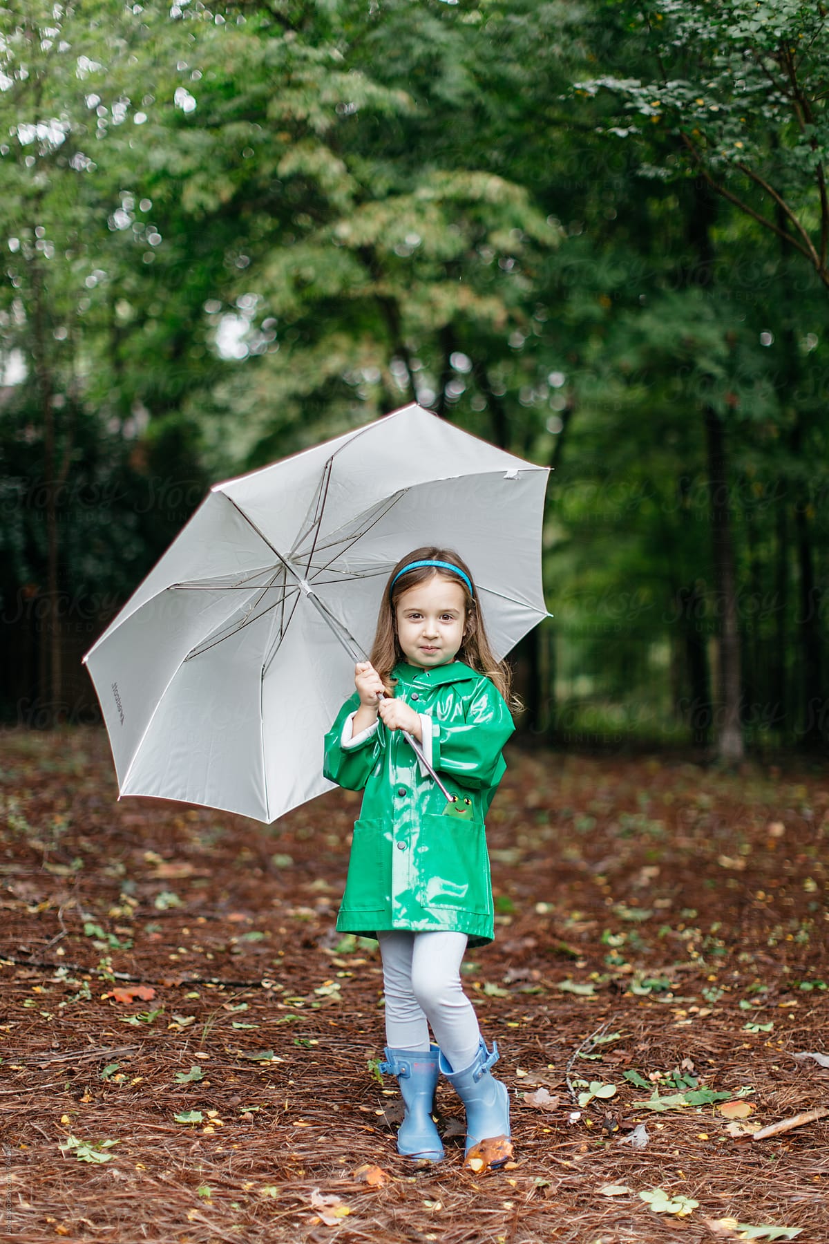 Cute young toddler with an umbrella and raincoat