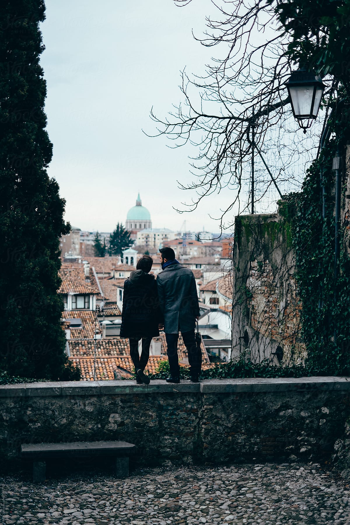 Back View of Young Couple Cuddling Visiting An Italian City