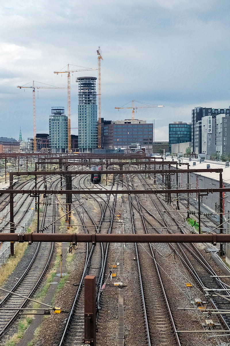 Urban view of a train station, with the city\'s skyline in the backdrop