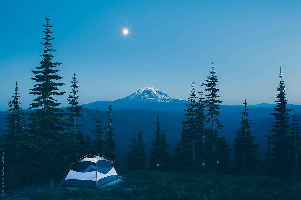 Camping tent in mountains at night with moon rise, Mt, Adams in distance