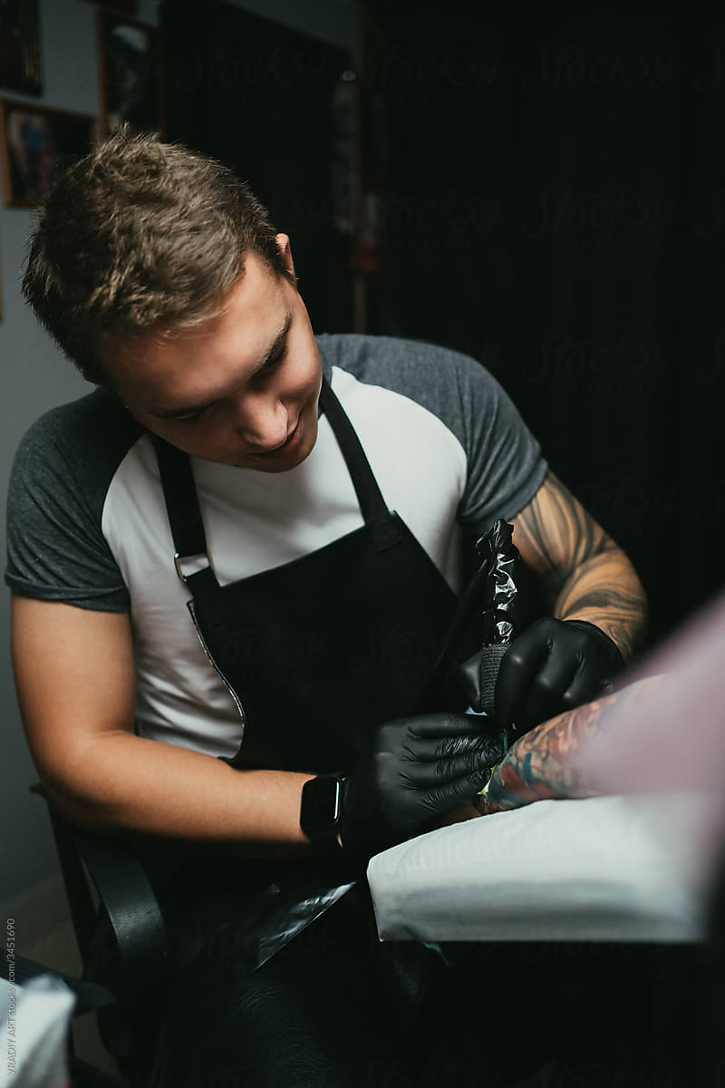 Tattooist working with client in salon