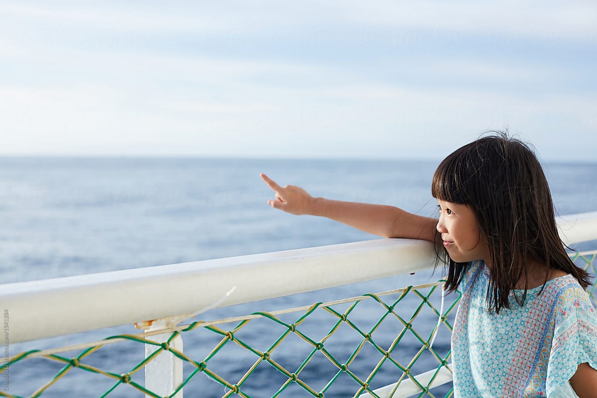 Asian little girl lying on the railing. On the cruise ship, the sea background