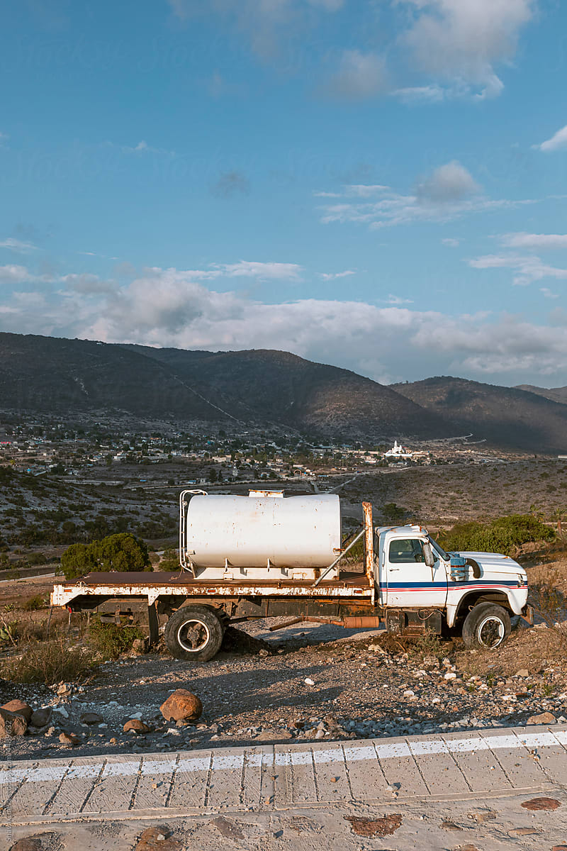 An abandoned white pipe truck in the mountains