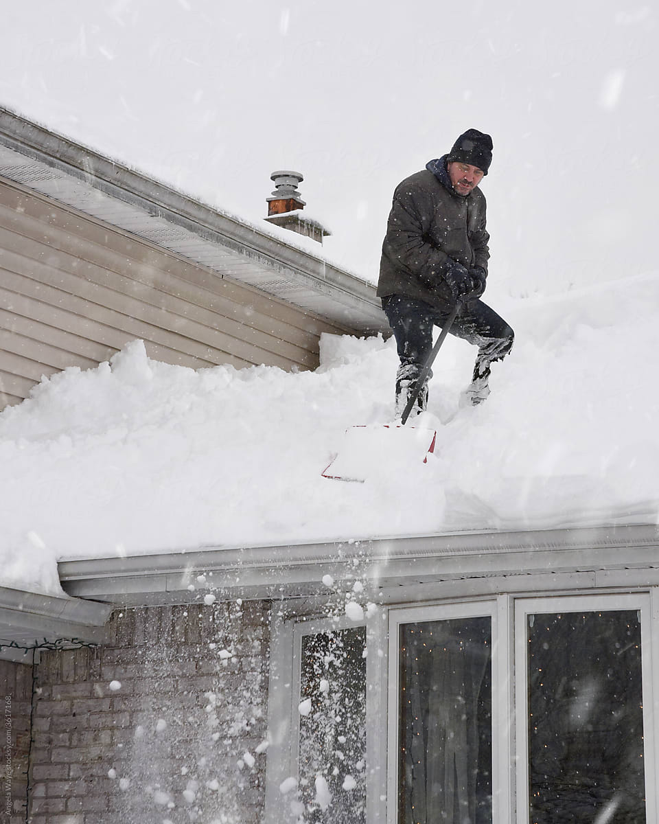 Man Shoveling Snow from Roof
