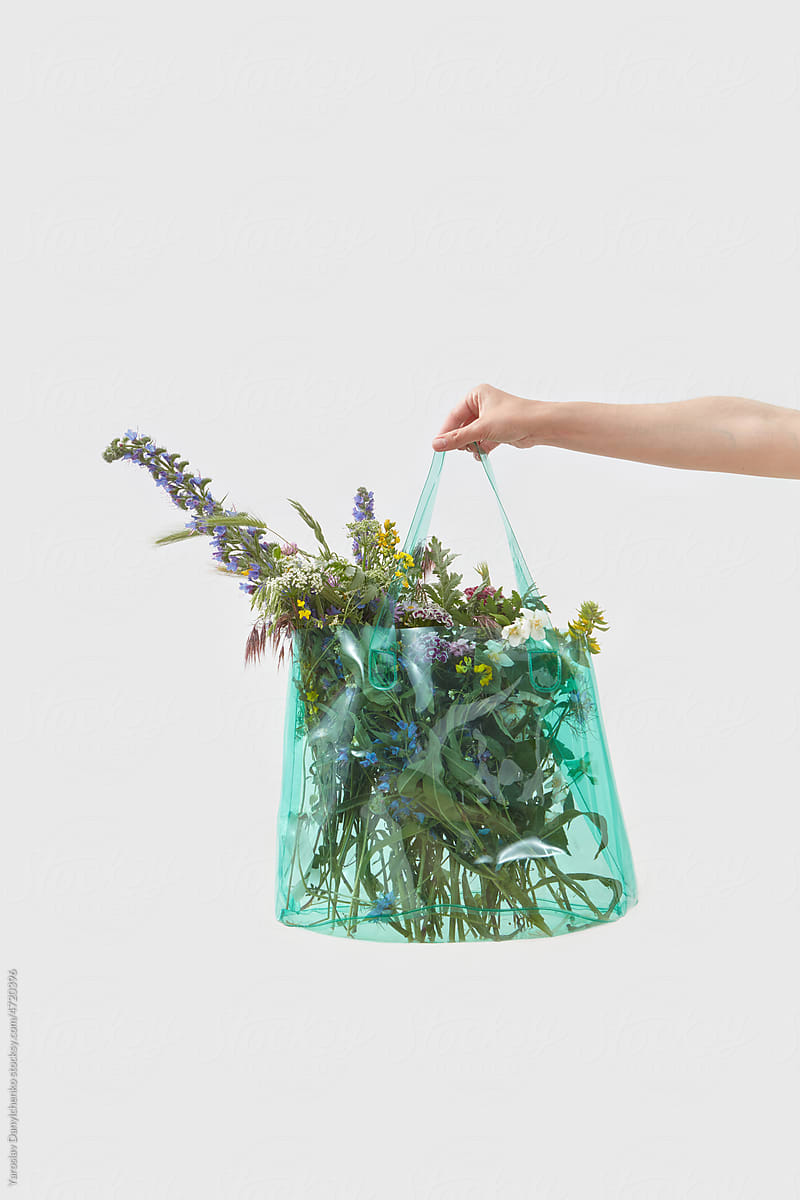 Woman holding recycled bag with flowers.