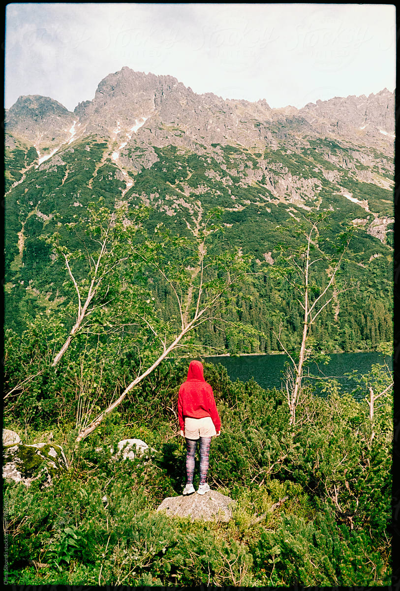 A traveler near a beautiful mountain lake and greenery